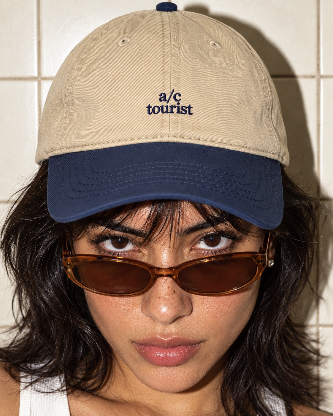 A/C Tourist Cap in Navy/Khaki worn by a model, front view, with navy “a/c tourist” embroidery