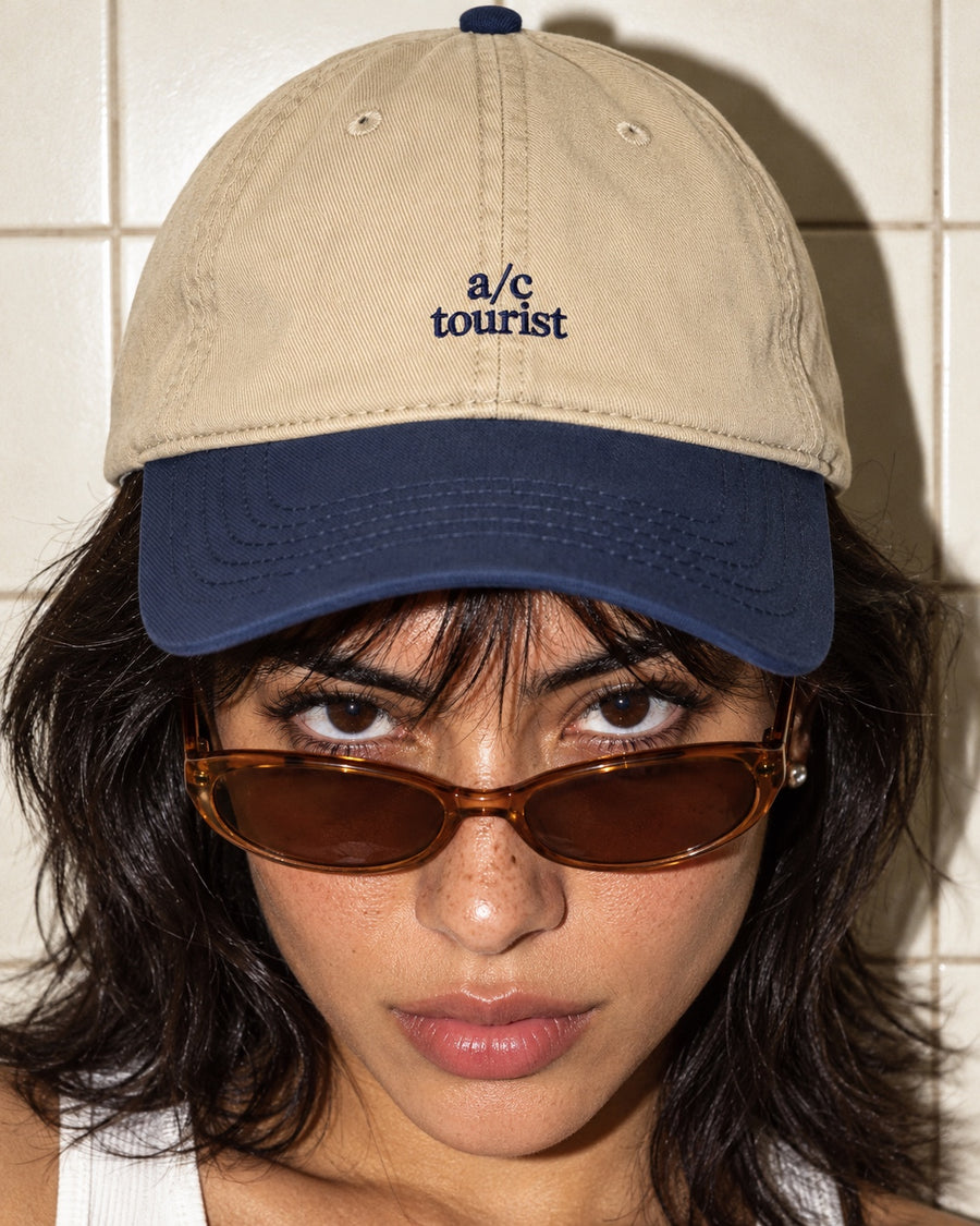 A/C Tourist Cap in Navy/Khaki worn by a model, front view, with navy “a/c tourist” embroidery