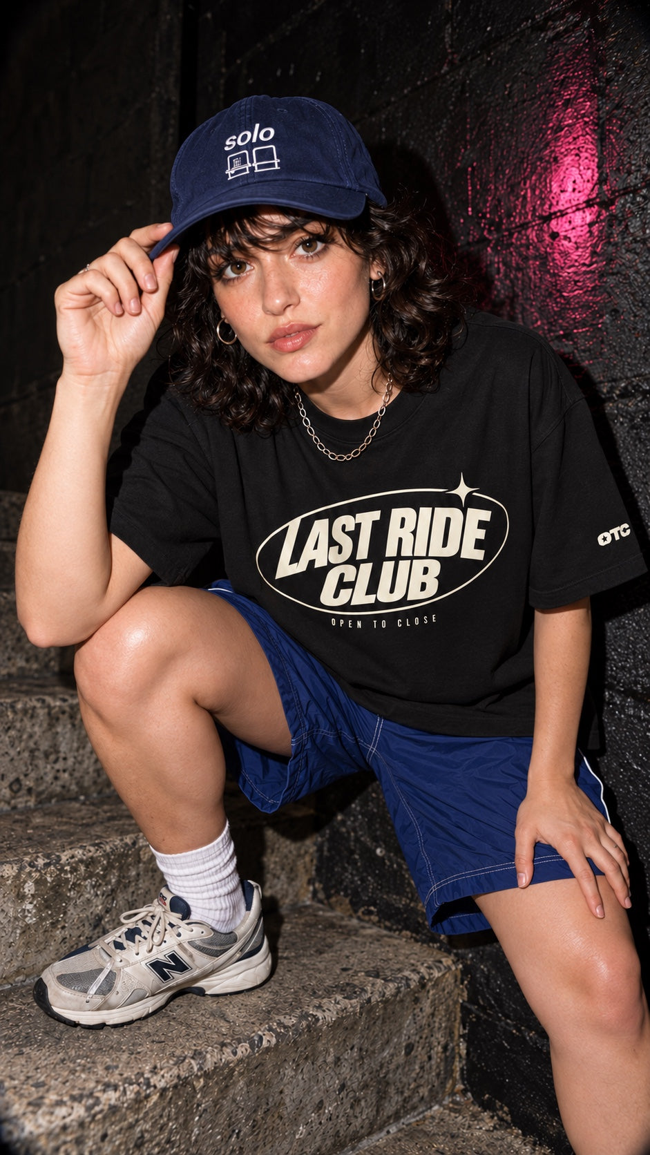 Last Ride Club Boxy Tee worn by a model with the Solo Cap, front view, on concrete steps at night