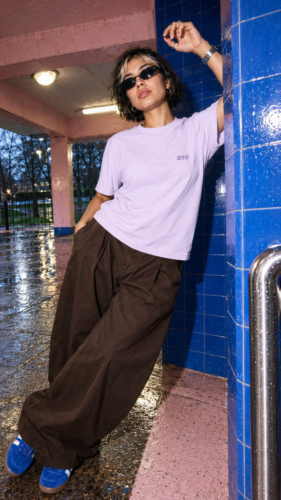Love This for Us Tee worn by a model, front view, by a tiled pillar in the rain