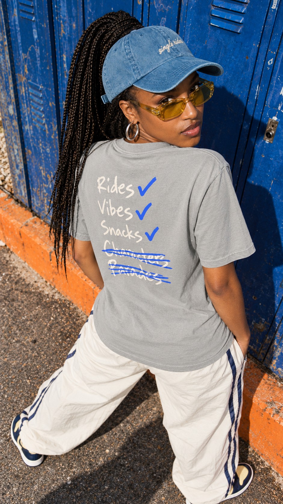 Rides, Vibes & Snacks tee worn by a model, back view, by a row of lockers