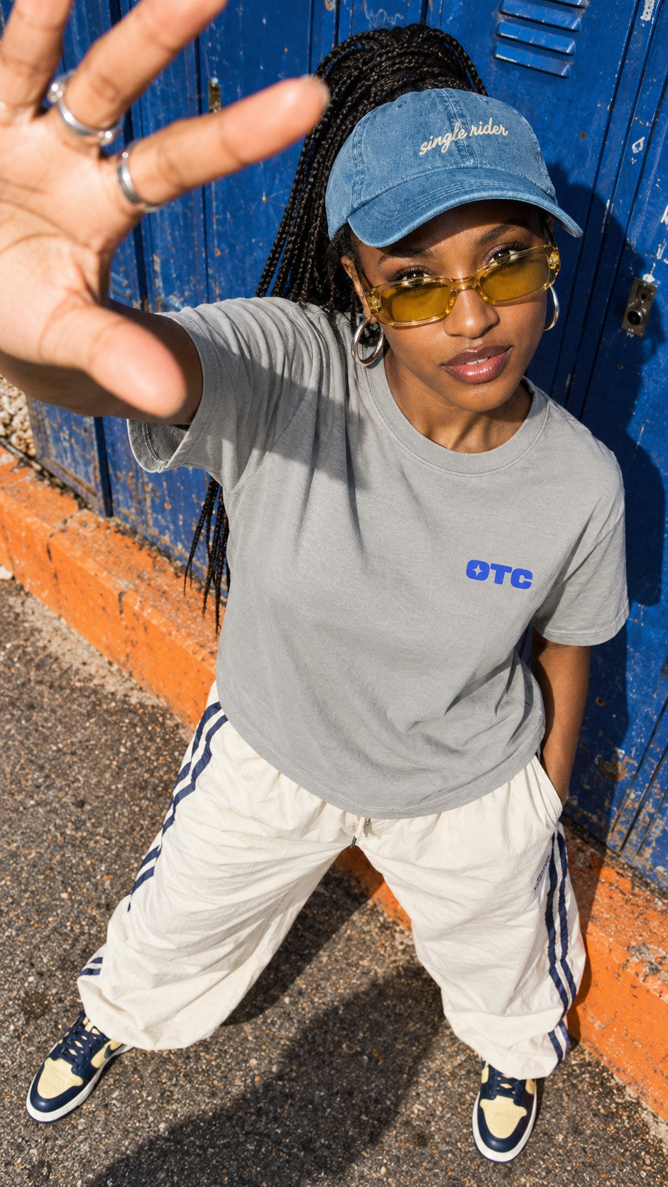 Rides, Vibes & Snacks tee worn by a model, front view, by a row of lockers