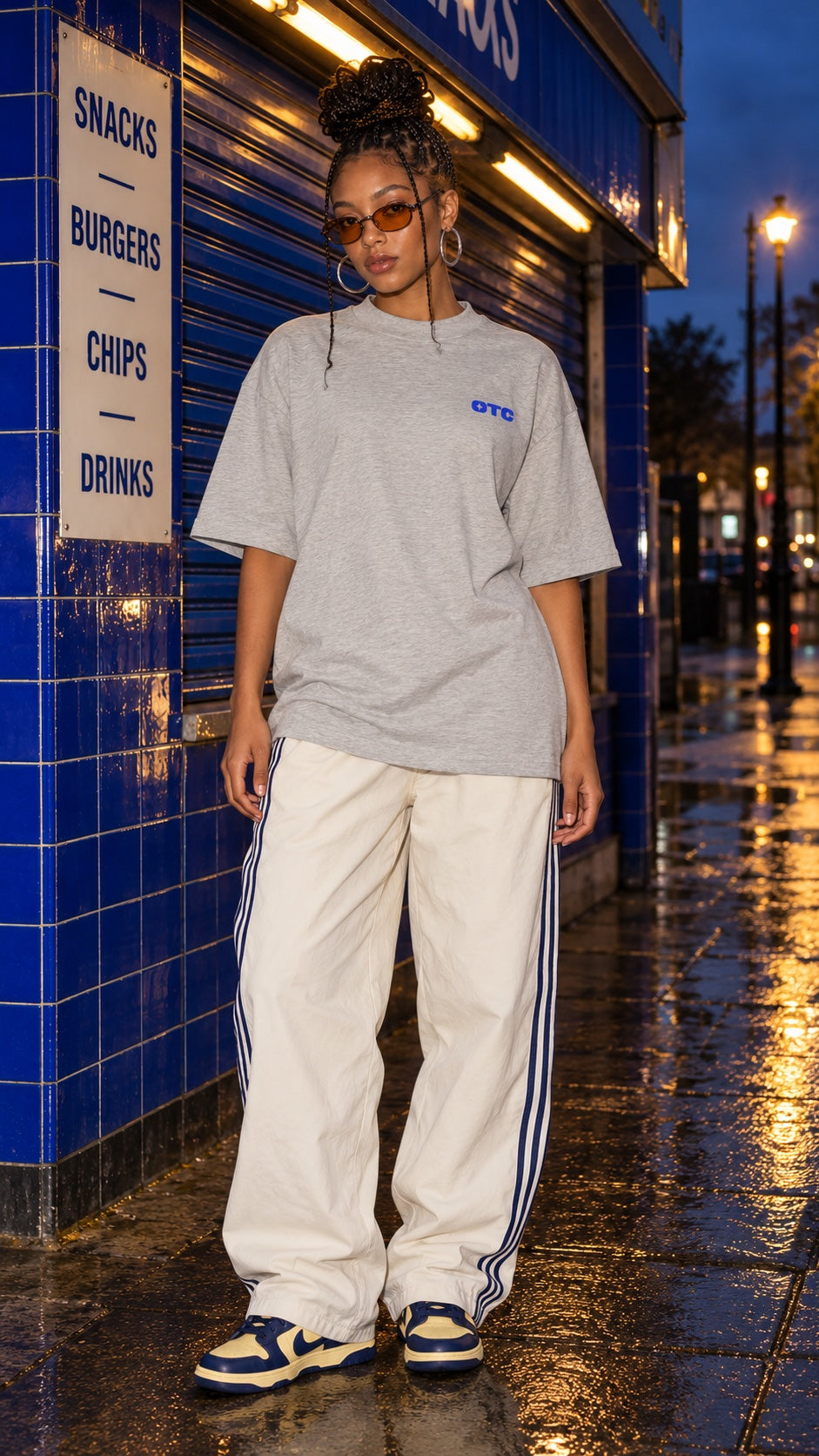 Rides, Vibes & Snacks Oversized Tee in heather grey worn by a model, front view, outside a snack bar at night