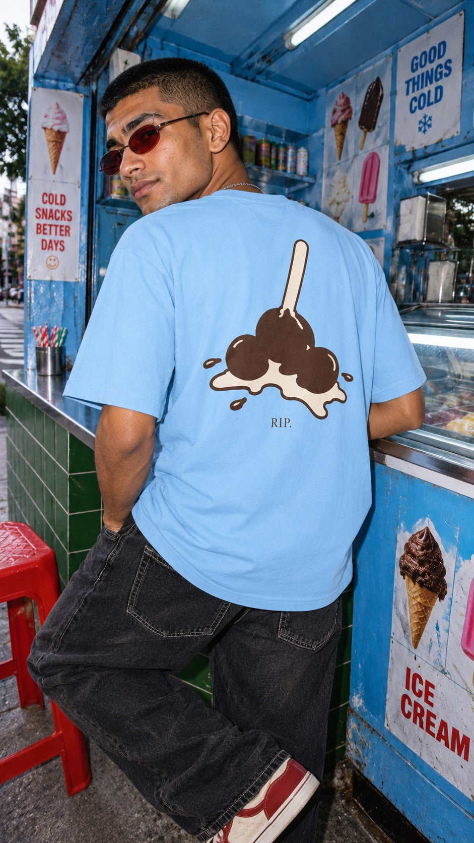 RIP Ice Cream tee worn by a model, back view, at an ice cream kiosk