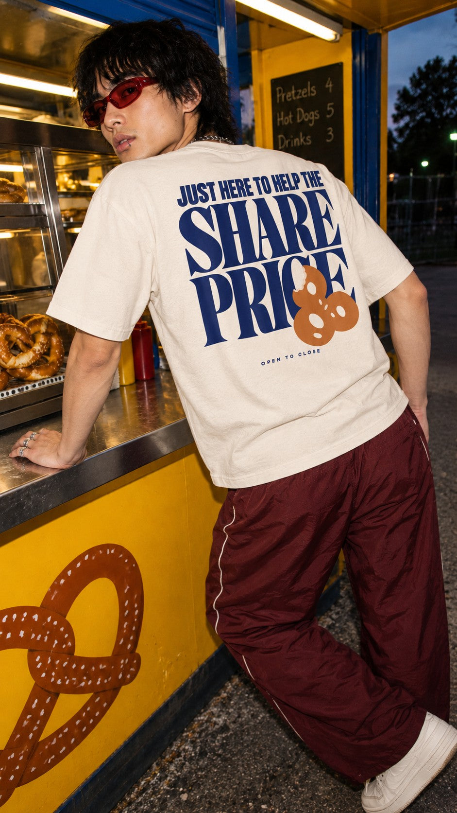 Share Price Boxy Tee worn by a model, back view, at a pretzel stand